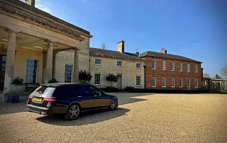 Luxury chauffeur vehicle outside a historic Derbyshire country house