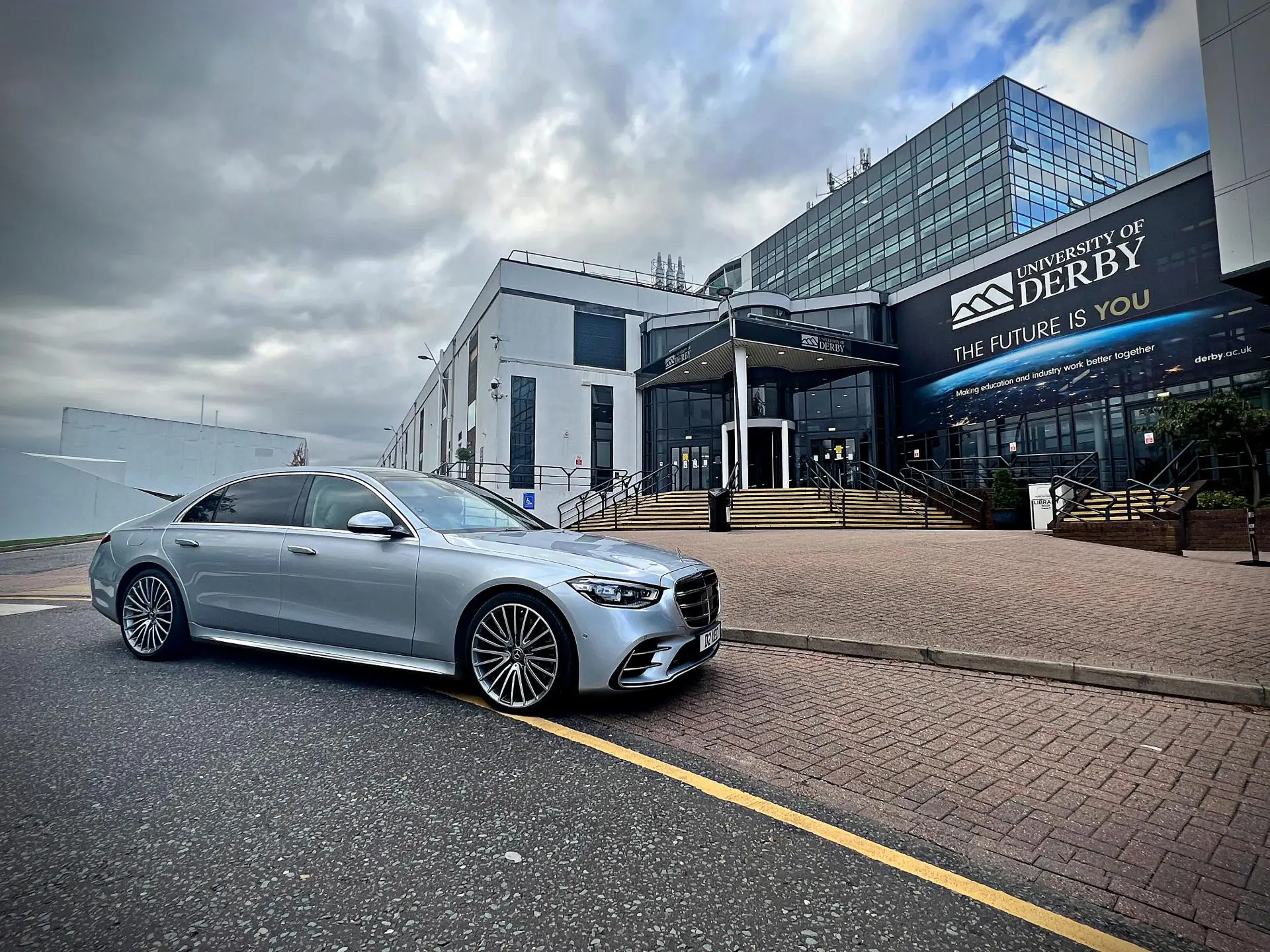 Mercedes S-Class executive chauffeur vehicle outside University of Derby campus