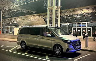 Mercedes V Class chauffeur vehicle collecting passengers at airport terminal